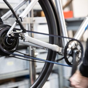 Nahaufnahme eines Fahrradantriebs mit Zahnriemen statt Kette in Bewegung.